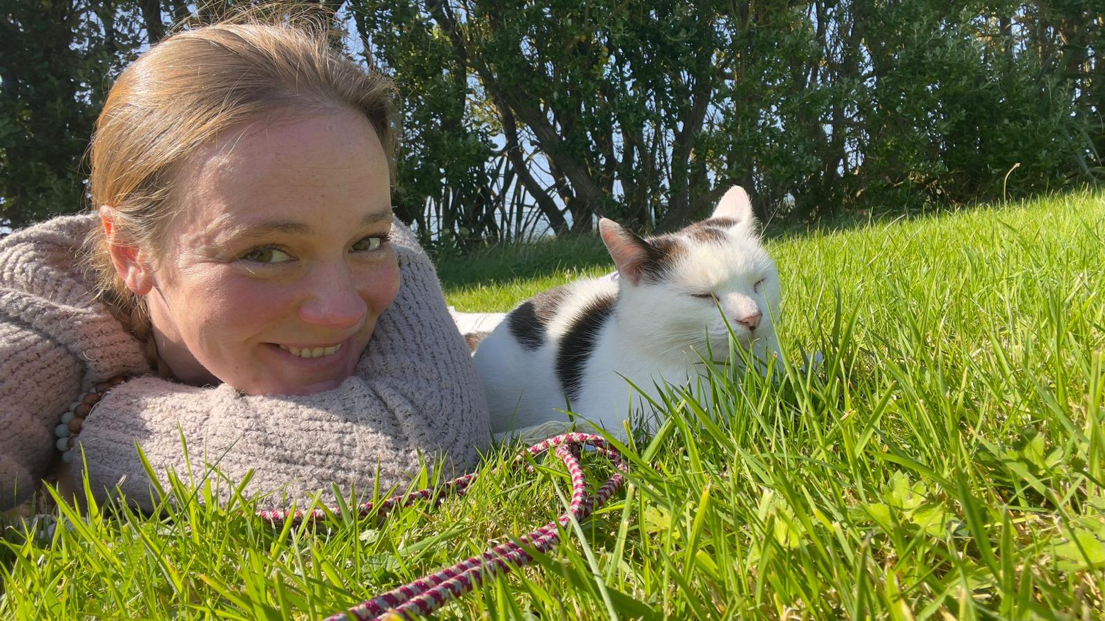 Nou lying in the green grass beside Casper.