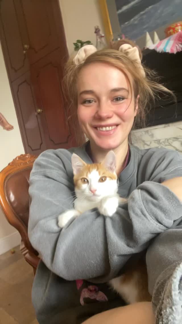 Me holding Tigger, an orange-and-white cat, close to me.